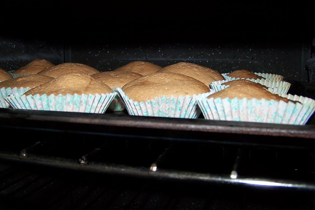 small cakes rising in the oven, where bakery sugar sets the crumb