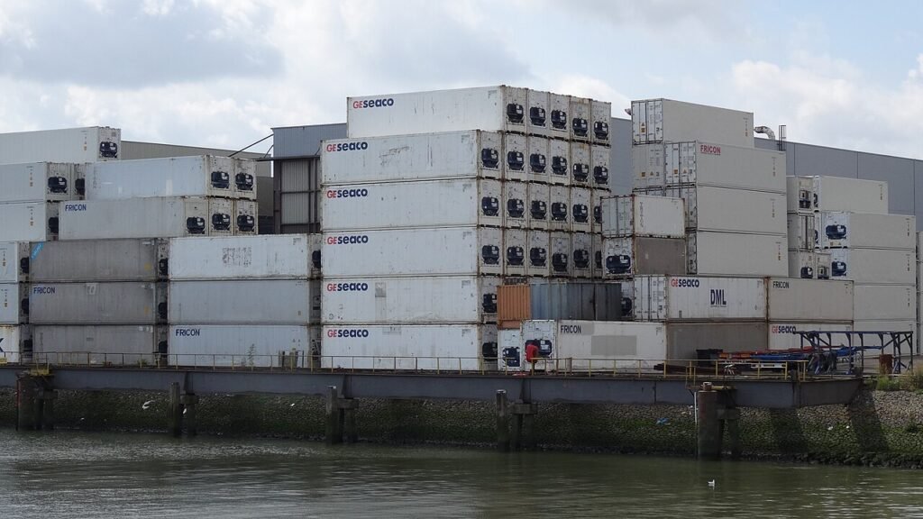 stacked shipping containers at a port where sugar arrives